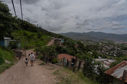 Una mujer y una niña caminan por la colonia Canaán.