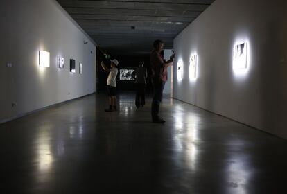 Visitantes toman fotos a los cuadros luminosos de Jim Campbell expuestos en la Fundación Telefónica.