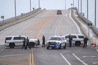 Patrullas de la policía bloquean la entrada a la playa en Belleair Causeway en medio de la lluvia y las ráfagas de viento.