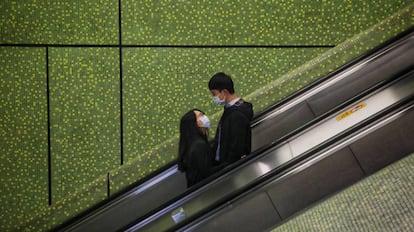 Una pareja vive su amor en tiempos ce coronovirus en un centro comercial de Hong Kong. 