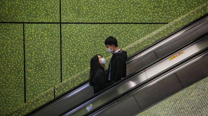 Una pareja vive su amor en tiempos ce coronovirus en un centro comercial de Hong Kong.