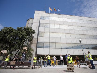 Una docena de trabajadores afectados por ERTE protesta frente a la delegación del SEPE en Barcelona.
