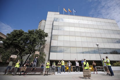 Una docena de trabajadores afectados por ERTE protesta frente a la delegación del SEPE en Barcelona.