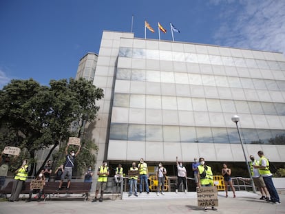 Una docena de trabajadores afectados por ERTE protesta frente a la delegación del SEPE en Barcelona.