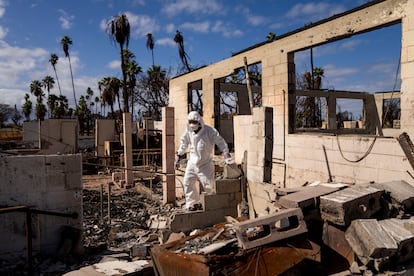 The Rev. Ai Hironaka, resident minister of the Lahaina Hongwanji Mission, walks through the grounds of his temple and residence destroyed by wildfire, Dec. 7, 2023, in Lahaina, Hawaii.