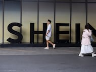 Dos personas pasan por delante de un logotipo de Shein en la localidad china de Guangdong.