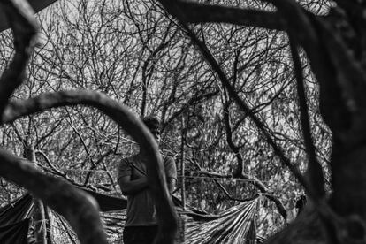 Un joven observa el movimiento en el exterior, cuando las autoridades se preparaban para iniciar con la salida de las primeras 27 personas del campamento.