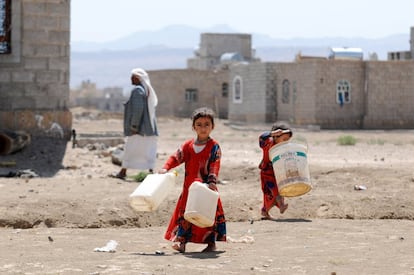 Dos hermanas pequeñas yemeníes llevan los bidones caminan a una bomba de agua para llenarlos de agua el pasado 18 de marzo de 2018 en Sana'a, Yemen. El conflicto ha destruido la mayoría de las infraestructuras, por lo que en muchas zonas no hay acceso a agua potable, lo que ha provocado que las condiciones higiénicas y sanitarias sean paupérrimas.