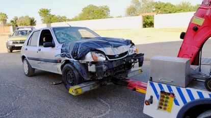 El coche con el que supuestamente una mujer ha atropellado a dos vecinos en una finca de Dos Hermanas, es sacado por una grúa de la finca.