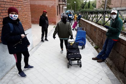 Varias personas hacen cola guardando la distancia social ante la sede del Banco del Bebé de la Fundación Madrina, en Madrid.