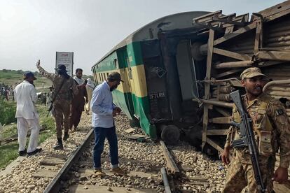 Militares y personal de rescate inspeccionan uno de los vagones del tren descarrilado.