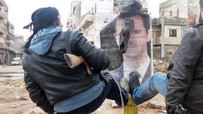 Rebeldes sirios derriban un cartel con el retrato de Bachar el Asad.