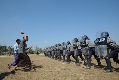 Un grupo de personas arrojan botellas de agua a los policías antidisturbios durante una sesión de entrenamiento para el control de multitudes propuesto por la Unión Europea para la Policía de Myanmar. La policía de Myanmar recrea métodos de control de masas como parte de un programa de formación de la UE para garantizar los derechos humanos en el ámbito policial y modernizar las técnicas utilizadas por las fuerzas de serguirdad.