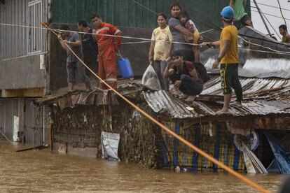 Varias personas esperan ser rescatadas durante las inundaciones en la población de Rodríguez (Filipinas). Cientos de personas han quedado atrapadas en los techos de sus casas esta noche debido a las inundaciones generalizadas provocadas por el paso del tifón 'Vamco', que ha dejado al menos un muerto y otros tres desaparecidos.