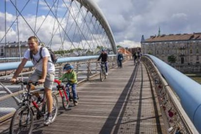 Ciclistas cruzando el río Vístula por el puente de Bernatka, en Cracovia.