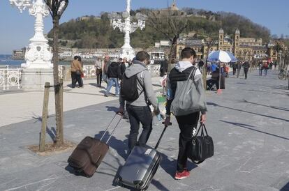 Dos jóvenes turistas con sus maletas camina por San Sebastián, en abril de 2015.