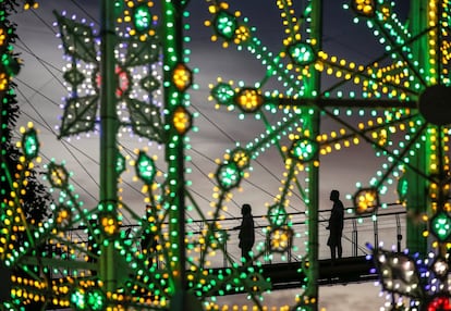 Dos personas observan desde una pasarela la instalación de luces navideñas en los jardines de la bahía de Singapur, el 1 de diciembre de 2017.