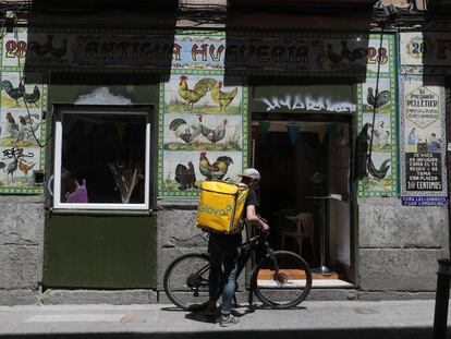 Un repartidor de comida, ante la antigua fachada de un local reconvertido en restaurante en Madrid.