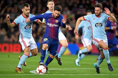 Lionel Messi (c) lucha por el balón entre los defensa del Celta Jonny Castro (i) y Sergi Gomez (d).