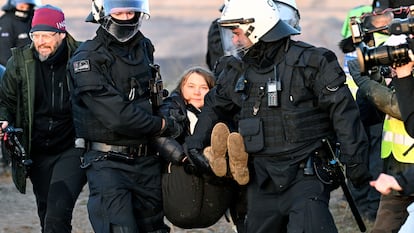 Police officers carry activist Greta Thunberg away from the edge of the Garzweiler II mine during a protest, after the clearance of Luetzerath, Germany, Tuesday, Jan. 17, 2023.