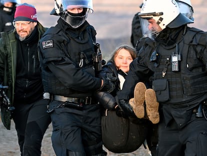 Police officers carry activist Greta Thunberg away from the edge of the Garzweiler II mine during a protest, after the clearance of Luetzerath, Germany, Tuesday, Jan. 17, 2023.