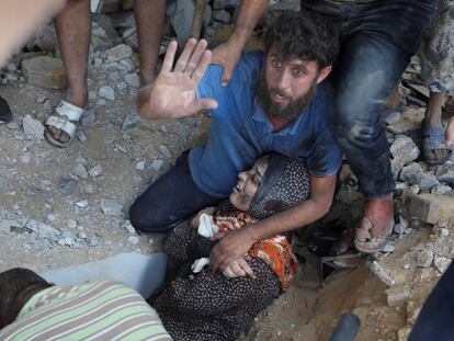 A Palestinian woman receives help after a house was bombed in the town of Rafah, in southern Gaza, on October 30, 2023.