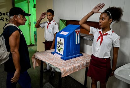 Estudiantes saludan después de que un hombre emitiera su voto en un colegio electoral durante el referéndum sobre el nuevo Código de Familia en La Habana 
