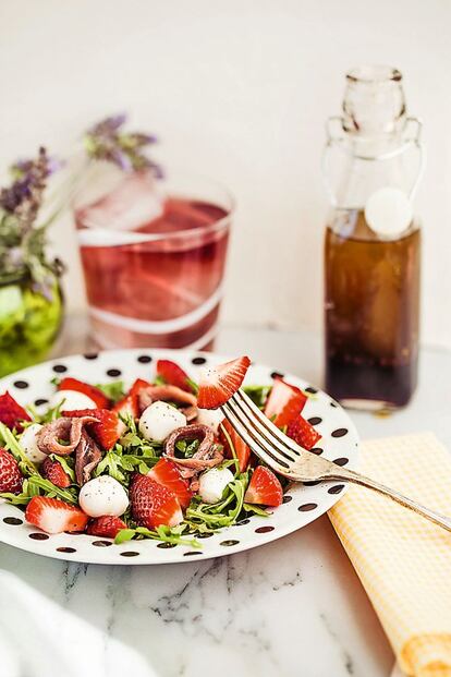 <p><b>Las fresas y el vinagre</b> se llevan bien: ponerles un chorrito de este a las fresas más ácidas es un truco popular que hace que saquen todo su dulzor. La mezcla de esta fruta con anchoas puede resultar más arriesgada, pero el contraste entre ambas y la untuosidad que aporta el aceite de oliva hace de esta una propuesta óptima para el verano.</p> <p><em>Ingredientes:</em> Para 4 personas: 150 gramos de rúcula, 300 gramos de fresas, 2 bolas de mozzarella de búfala (o 16 mozzarellas en miniatura), un puñado de brotes de cebollino (opcional), 12 filetes de anchoa, sal, pimienta, 2 cucharadas de vinagre de moscatel o Pedro Ximénez, 4 cucharadas de aceite de oliva virgen extra, sal, pimienta rosa.</p> <p><em>Preparación:</em> 1. Mezclar el vinagre con la sal y el aceite, haciendo una vinagreta. 2. Lavar las fresas y cortarlas en cuartos o en octavos, si son muy grandes. 3. Montar la ensalada poniendo una base de rúcula y (si se quiere) cebollino, después las fresas y encima la mozzarella, terminando con los filetes de anchoa, y aliñando con la vinagreta y un toque de pimienta.</p>