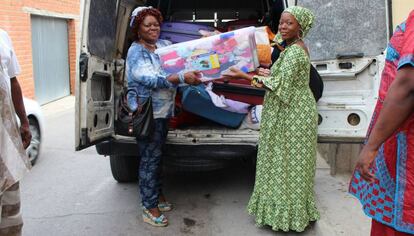 Dos mujeres descargan artículos de primera necesidad donados para migrantes en situación de vulnerabilidad.