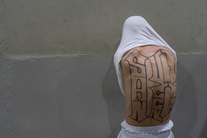 Nadie que haya entrado esposado ha vuelto a ver la luz del día. Solo un torrente de aire se cuela por una abertura en el techo a la que es imposible trepar por las paredes lisas. En la imagen, un reo muestra los tatuajes de su espalda. 