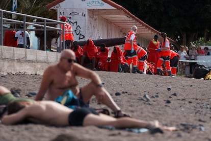 Dos turistas tomaban el sol el 1 de enero en la playa de Las Galletas (sur de Tenerife), mientras, de fondo, la Cruz Roja atendía a los ocupantes de un cayuco, entre los que se encontraban dos cadáveres.