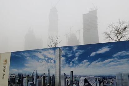 Un cartel promocional de una futura construcción contrasta con el actual cielo de Pekín (China).