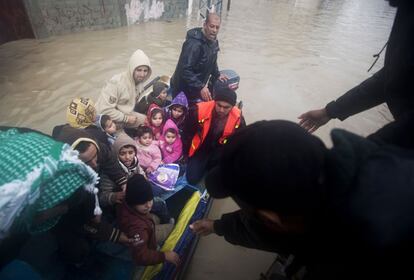 Voluntarios palestinos evac&uacute;an de sus casas en barcas a gente que se ha quedado atrapada por las inundaciones en Gaza.