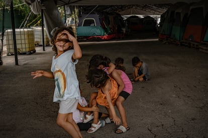 Meninos e meninas de várias nacionalidades brincam ao lado das tendas montadas no abrigo Pumarejo, em Matamoros.