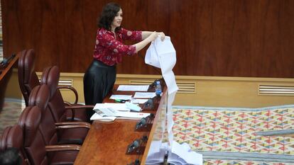 La presidenta de la Comunidad de Madrid, Isabel Díaz Ayuso, despliega en el parlamento regional un rollo de papel en el que dice que aparecen traslados de residentes madrileños a hospitales durante la primera ola de la pandemia de coronavirus, el 11 de junio de 2020.