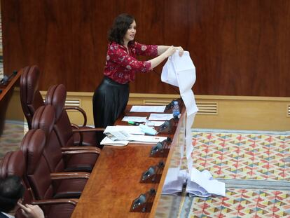 La presidenta de la Comunidad de Madrid, Isabel Díaz Ayuso, despliega en el parlamento regional un rollo de papel en el que dice que aparecen traslados de residentes madrileños a hospitales durante la primera ola de la pandemia de coronavirus, el 11 de junio de 2020.