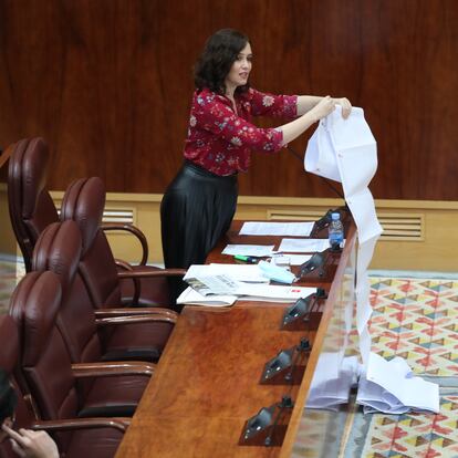 La presidenta de la Comunidad de Madrid, Isabel Díaz Ayuso, despliega en el parlamento regional un rollo de papel en el que dice que aparecen traslados de residentes madrileños a hospitales durante la primera ola de la pandemia de coronavirus, el 11 de junio de 2020.