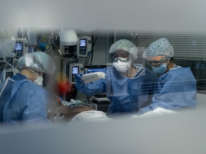 Health workers help a Covid-19 patient in Barcelona‘s Cliníc Hospital.