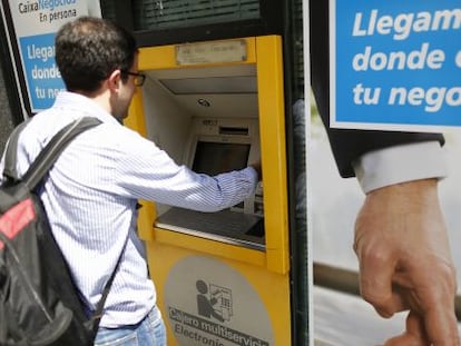 Un joven utiliza un cajero autom&aacute;tico de CaixaBank, en Madrid.