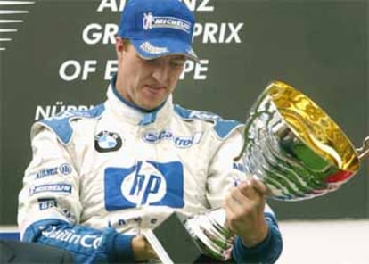 Ralf Schumacher observa el trofeo de vencedor del GP de Europa.