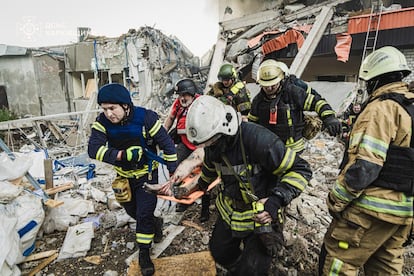 En esta imagen proporcionada por el Servicio de Emergencias de Ucrania, personal sanitario traslada el cuerpo de una víctima tras un ataque con cohetes rusos sobre Járkov, este martes.