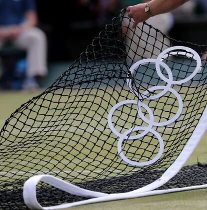 Un operario retira la red de la Pista Central al terminar la final de tenis en la que el británico Andy Murray ha derrotado al suizo Roger Federer.