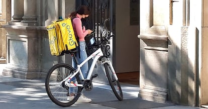 Una trabajadora de Glovo ante un portal en Barcelona.