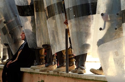 Una mujer descansa, a los pies de policías antidisturbios, en medio de una protesta en la plaza Tahrir (Liberación) de Bagdad.