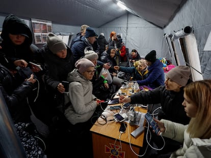 Ciudadanos de Kiev cargaban el pasado jueves las baterías de sus móviles, usaban internet y se calentaban en uno de los puntos habilitados en la capital ucrania.