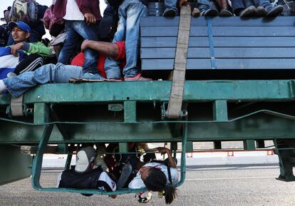 Migrantes que forman parte de la 'caravana de migrantes' descansan en un camión mientras se dirigen a Tijuana, cerca de Mexicali (México).