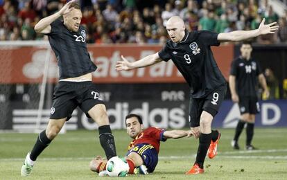 Sergio Busquets disputa el balón con dos futbolistas irlandeses
