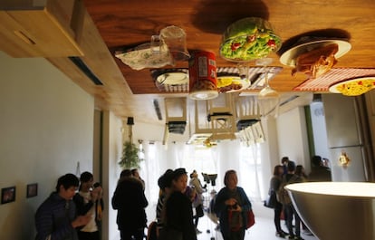 Visitors look around inside an upside-down house created by a group of Taiwanese architects at the Huashan Creative Park in Taipei, Taiwan, Tuesday, Feb. 23, 2016. With a build price of $600,000 and over 300 square meters (3,230 square feet) of floor space filled with real home furnishings, the upside-down house will continue to be on display to visitors until July 22. (AP Photo/Wally Santana)