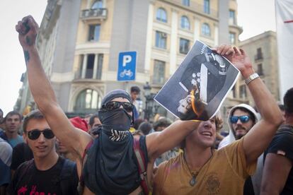 Un manifestante que pretendía impedir el homenaje a los policías del 1-O quema una fotografía de Felipe VI.