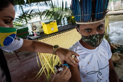 Una trabajadora del Distrito Sanitario Especial Indígena vacuna en la Amazonía.